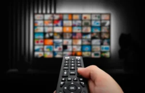 Télécommande et TV avec plusieurs chaînes disponibles via un abonnement IPTV d’une agence IPTV en France